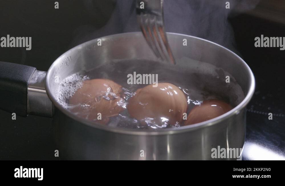 Three eggs boiling in a saucepan on an induction hob Stock Video
