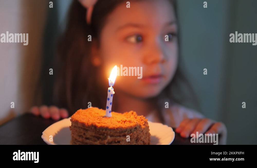 Adorable little girl blow out a candle on a birthday cake Stock Video