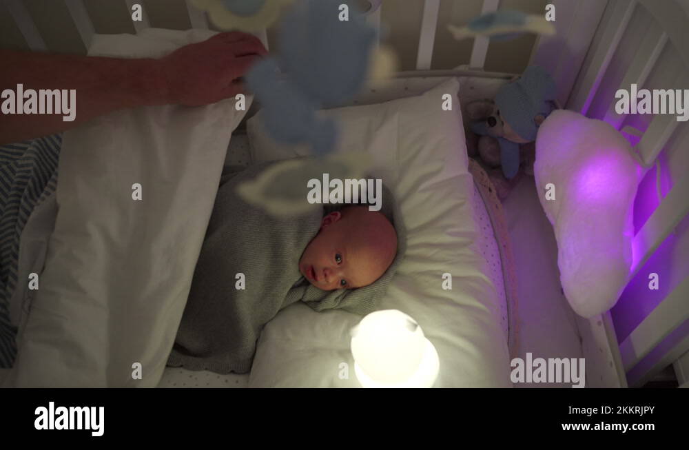 father putting his baby to sleep in a crib, 3weekold newborn in bed Stock Video Footage Alamy