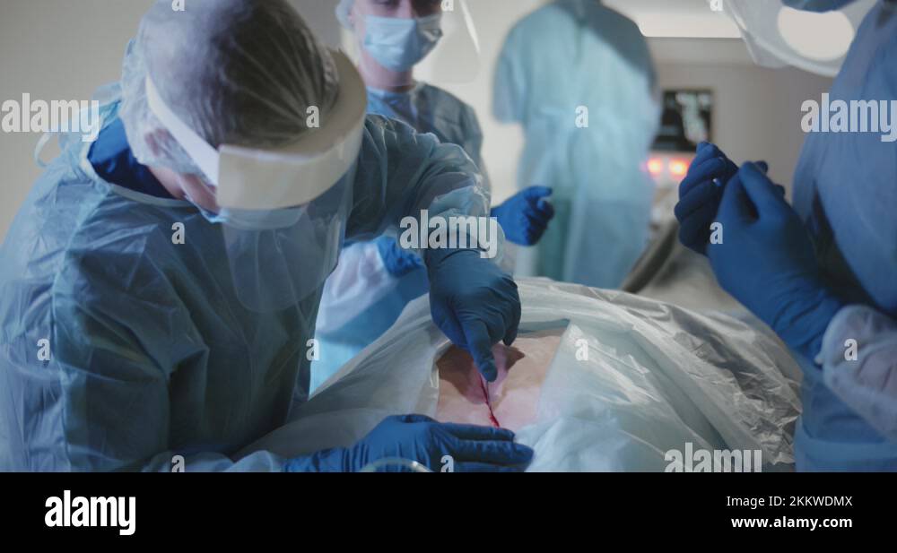 Medical team performing surgical operation to patient in operating room
