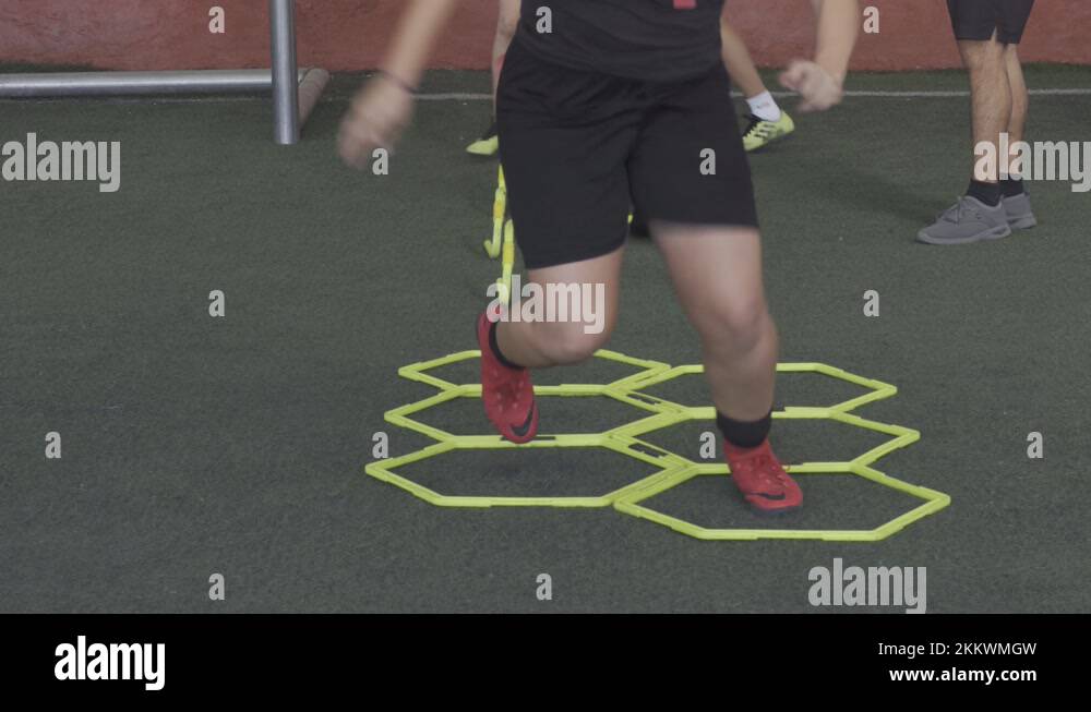 A football player on a hexagonal speed and agility training ladder