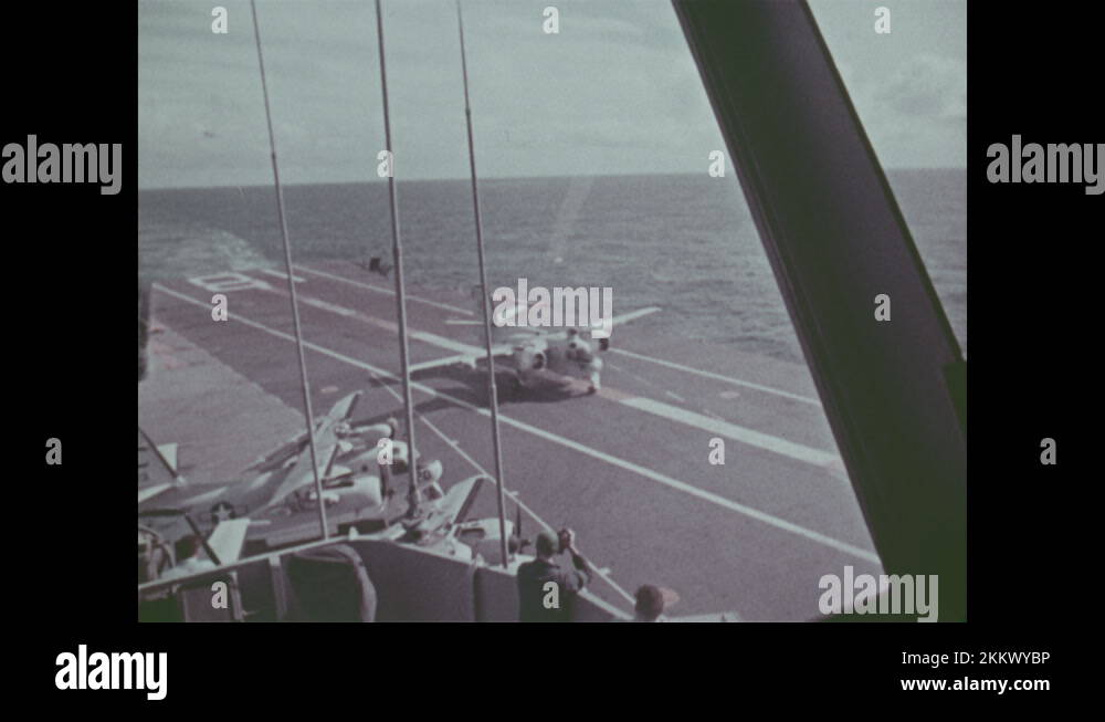 1960s Men in bridge of ship. Plane lands on aircraft carrier. Man