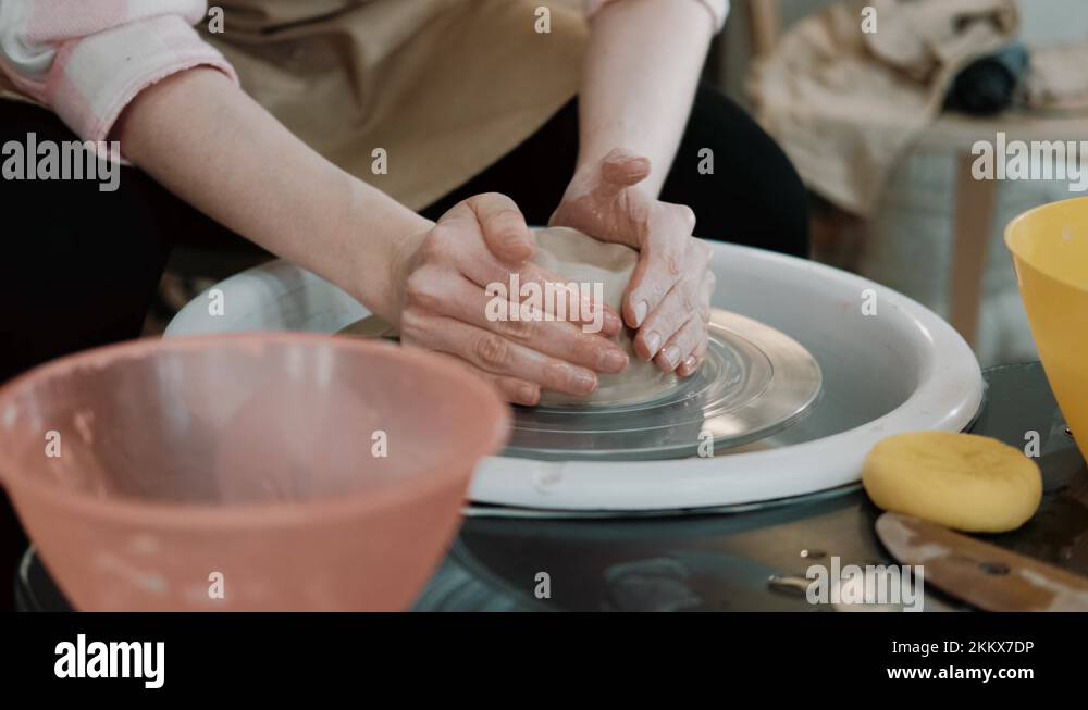 Potter shapes the clay product with pottery tools on the potter's wheel
