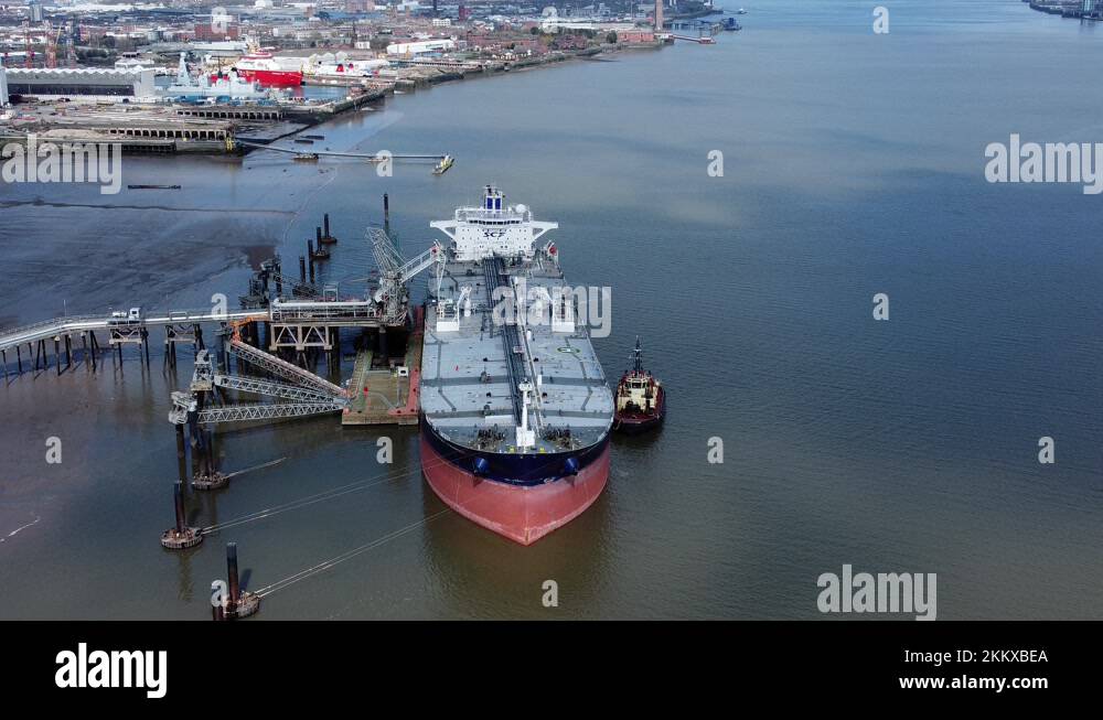 Crude oil tanker ship loading at refinery harbour terminal aerial high