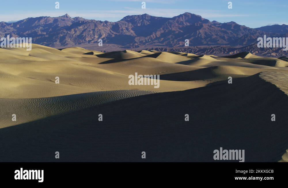 8K golden sand dunes with shades and rocky mountains in Death Valley ...