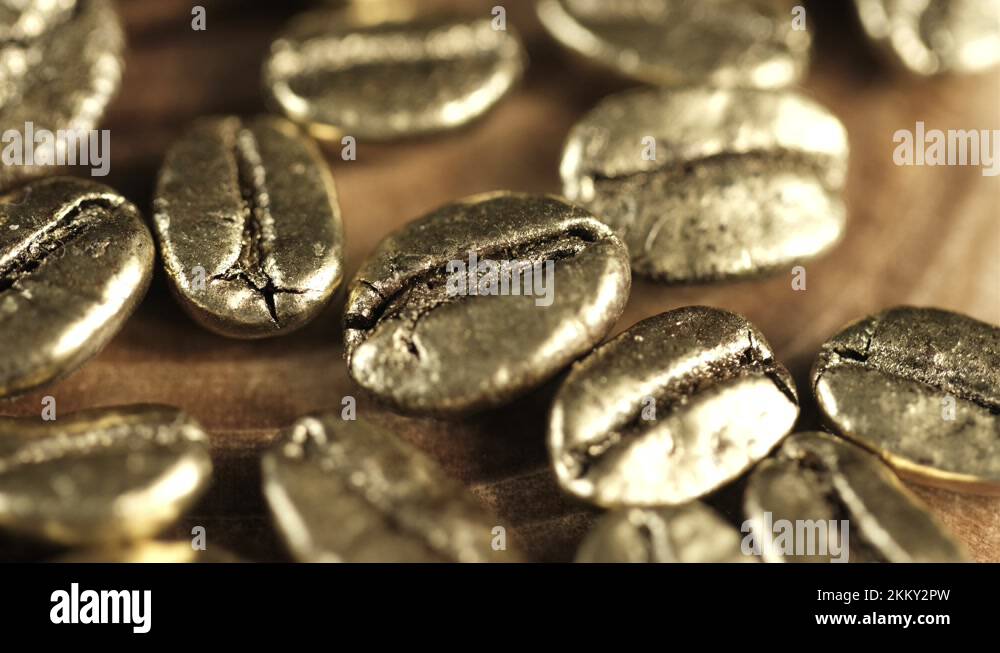 Golden coffee beans. Many gold coffee beans slowly rotate. 4K Stock