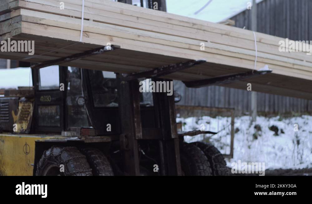 Forklift load packs of lumber boards on lorry cart at sawmill factory