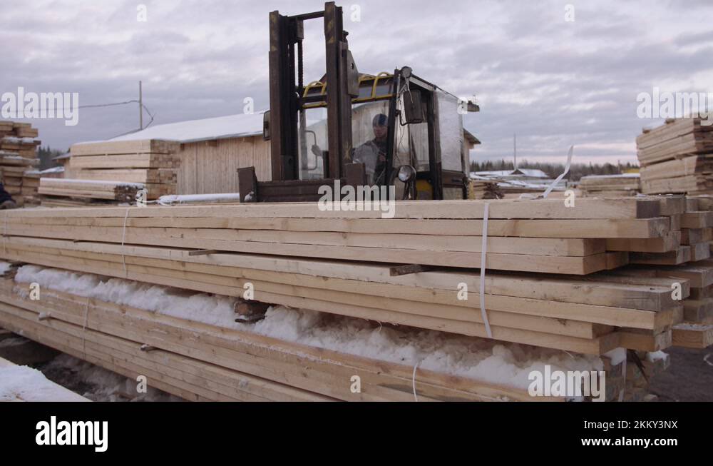 Forklift load packs of lumber boards on wagon lorry at sawmill factory