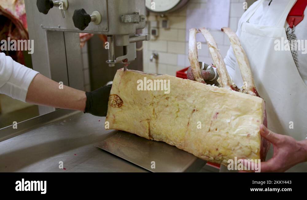 butcher cutting dry aged tbones with sowing cutting machine Stock