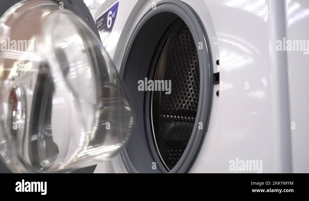 Open the Door of the Washing Machine. A Customer Inspects a New Washing