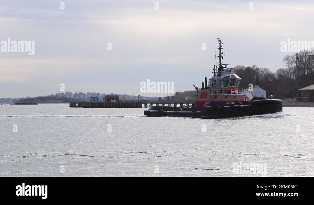 Tug Boat moving across frame in a harbor setting, static tripod. Hull