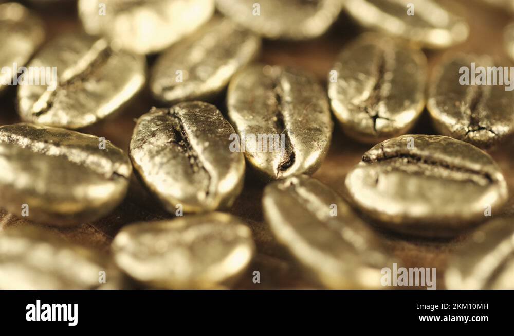 Golden coffee beans. Many gold coffee beans slowly rotate. 4K Stock