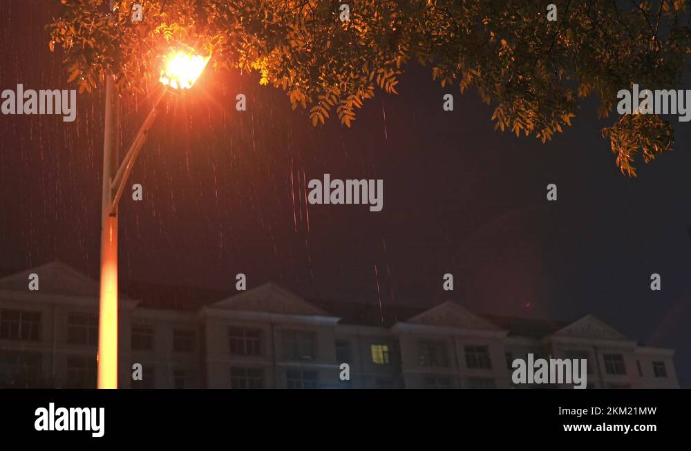 A street light outside a residential complex illuminating rain Stock