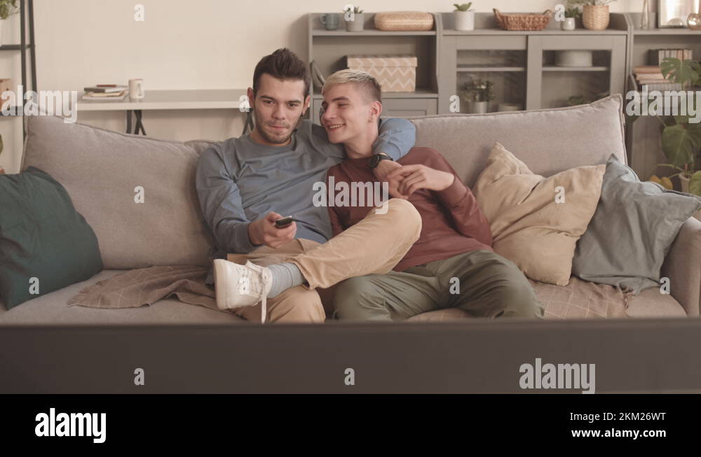 Two Young Men Sitting in Hug and Watching TV Stock Video Footage - Alamy