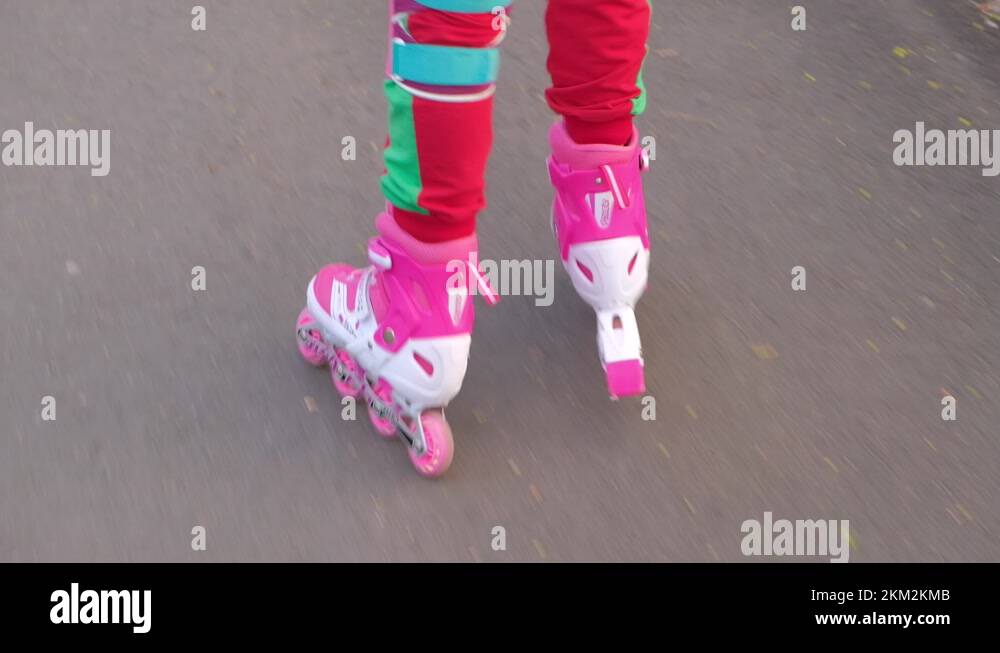 Little girl wearing protection pads and safety helmet learning to