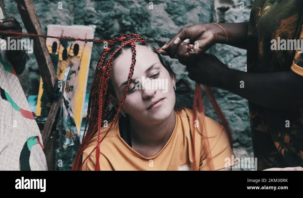 Process of Weaving African Braids with Red Kanekalon Outdoor, Zanzibar