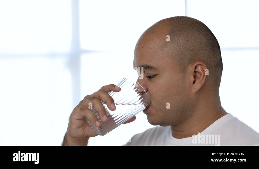 A young man drinking clean water from a clear glass For good health, drink water Stock Video