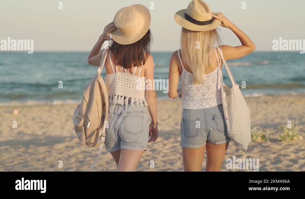 A back view of a young girls walking together on the beach Stock Video ...