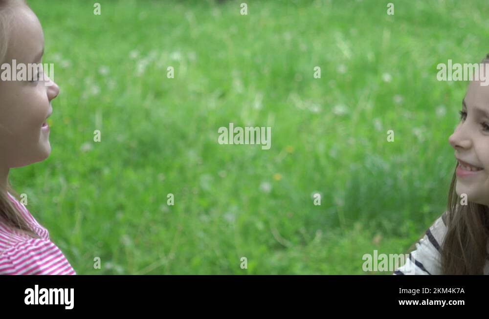 Two girls in the park and playing rock paper scissors hand game Stock