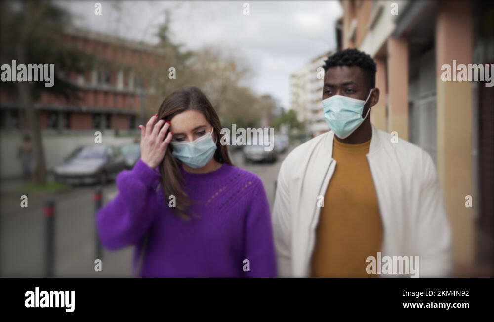 Diverse people walking in city wearing covid19 face mask. Black man