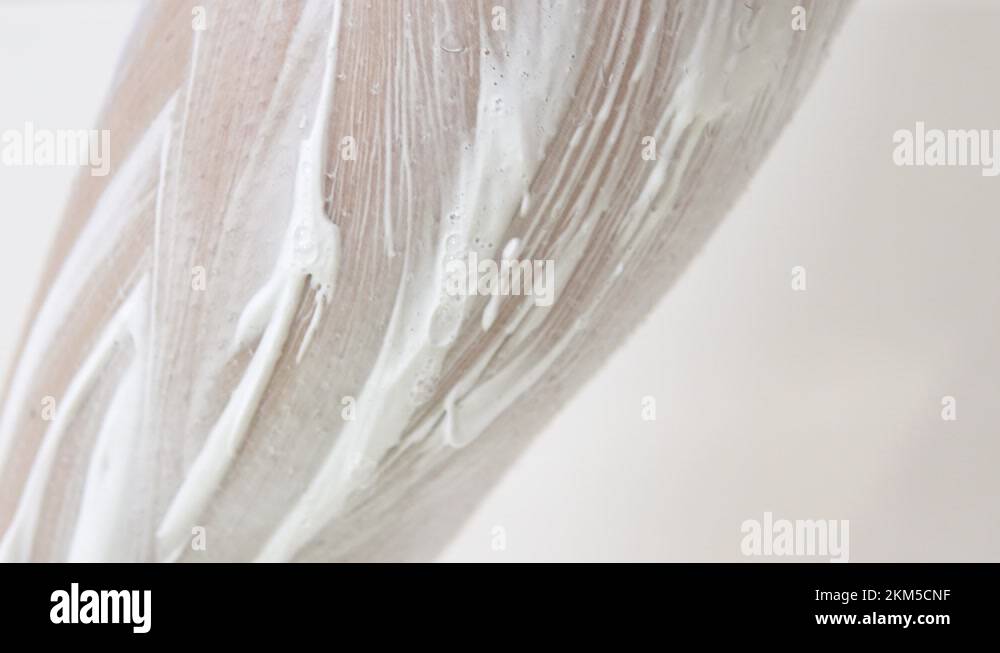 A young woman shaves hair on her legs. The girl applied shaving foam on