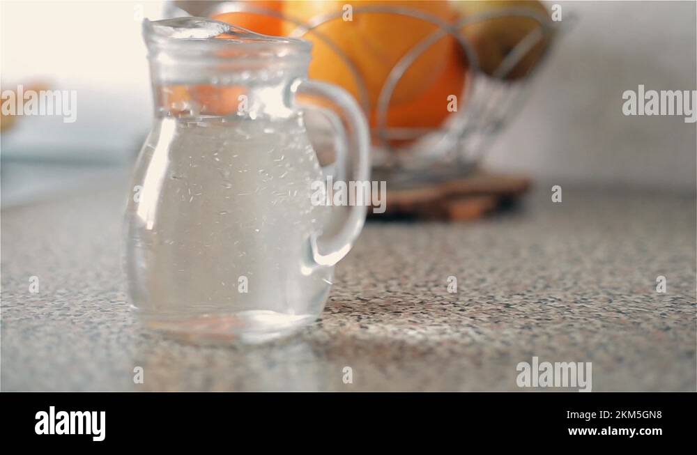 The child pours from a plastic bottle into a jug of clean drinking
