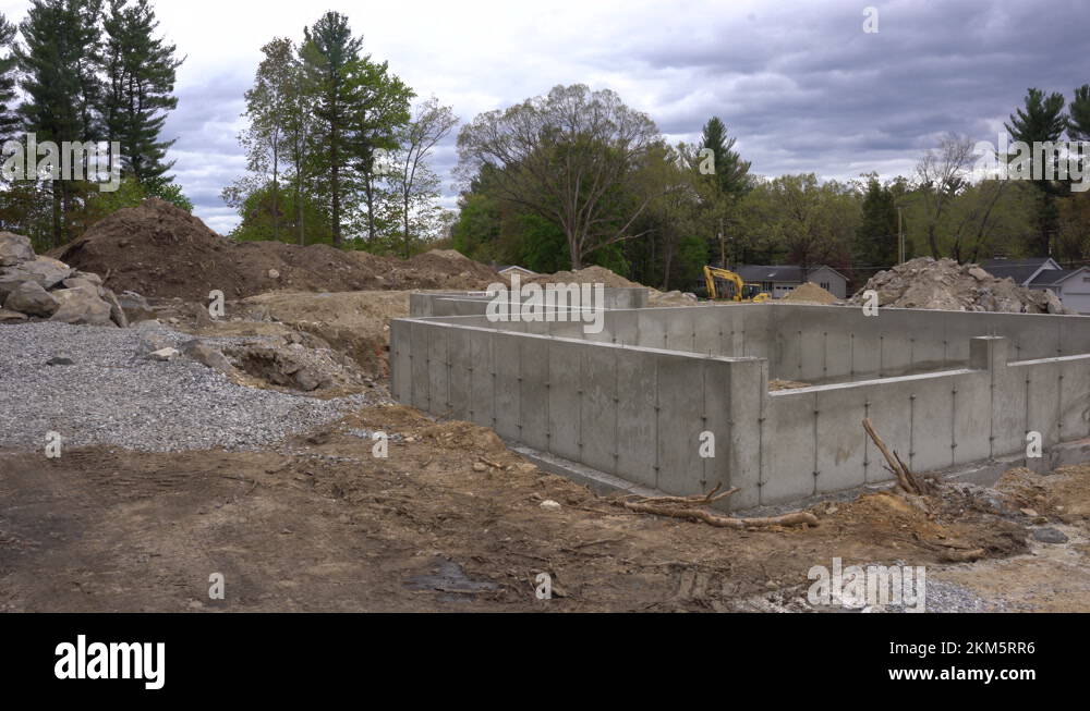Pan across a new concrete foundation to a newly constructed house in
