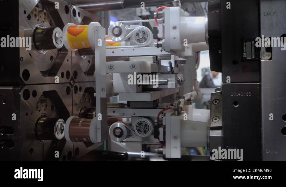 Plastic Injection Machine Motion Injection molding machine during work: production of plastic cups: slow ...