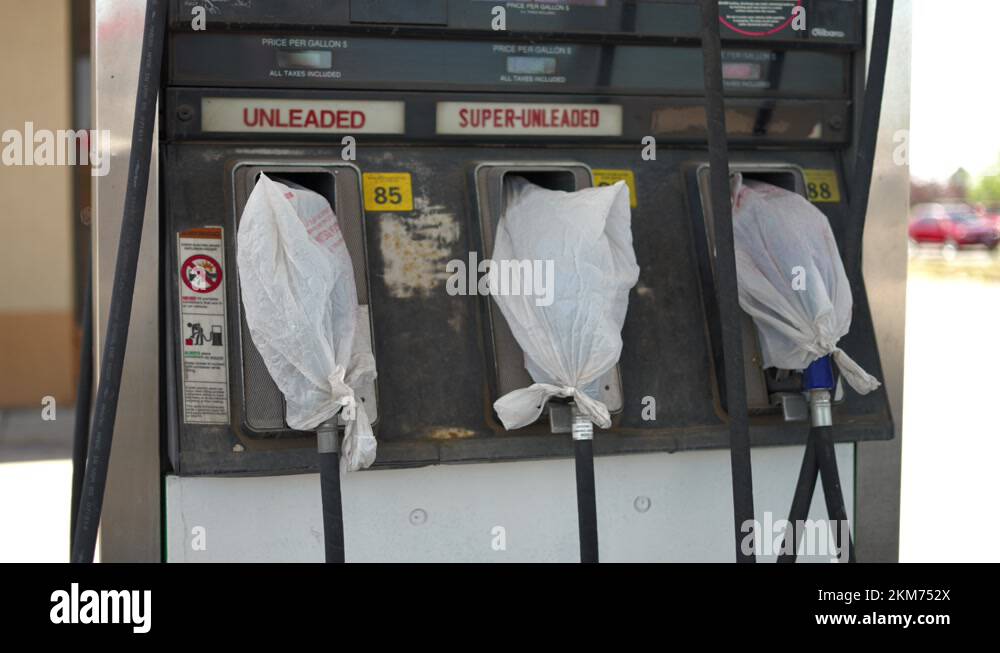 Gas pumps at shut down fuel petrol station with plastic bags on all the