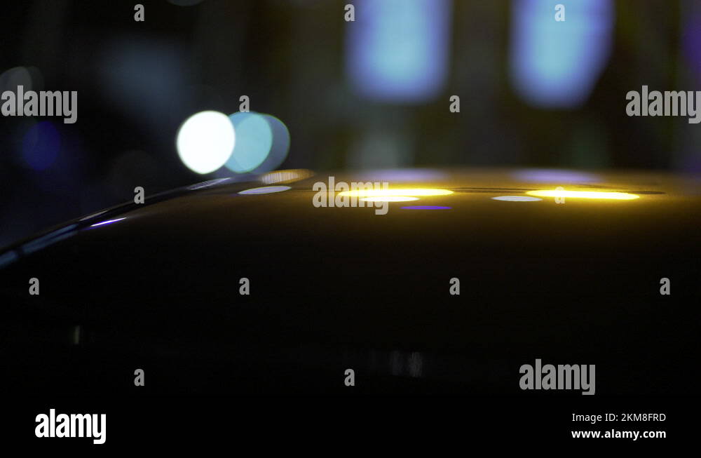 Blurry blinking emergency lights reflected in metallic surface at night