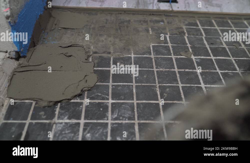 The process of laying ceramic floor tiles. Spreading wet mortar before