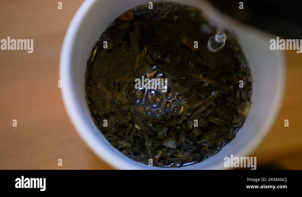 Closeup Of Pouring Boiling Water Into A Cup Of Green Tea, Healthy Drink