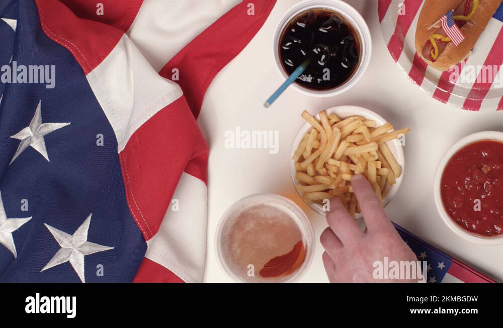 Top Down Shot of Hands Taking Fries and a Beer from a July 4th Party