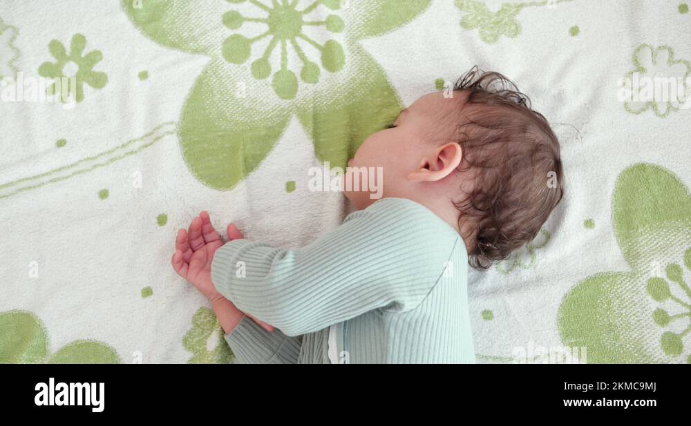 Sleeping cute baby boy on bed. Peaceful baby son sleeping on bed in a