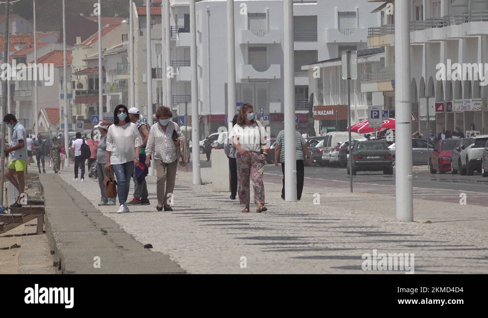 Women wearing face masks walk along promenade in beach town Portugal