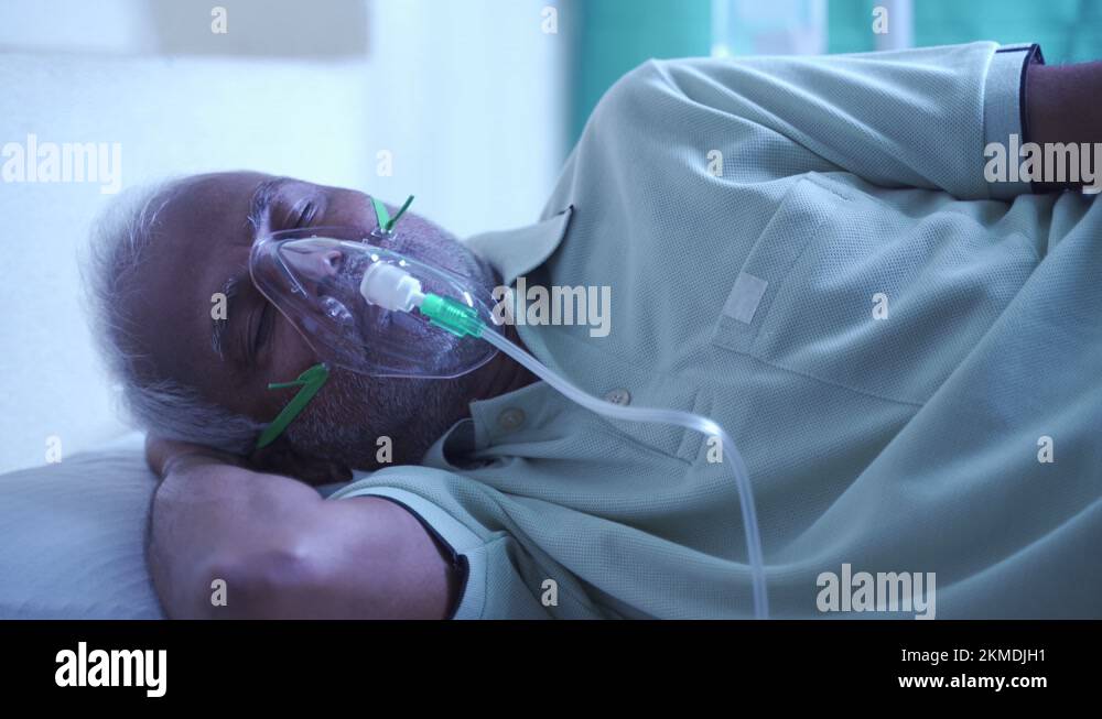 Senior patient is breathing oxygen while sleeping on bed Stock Video
