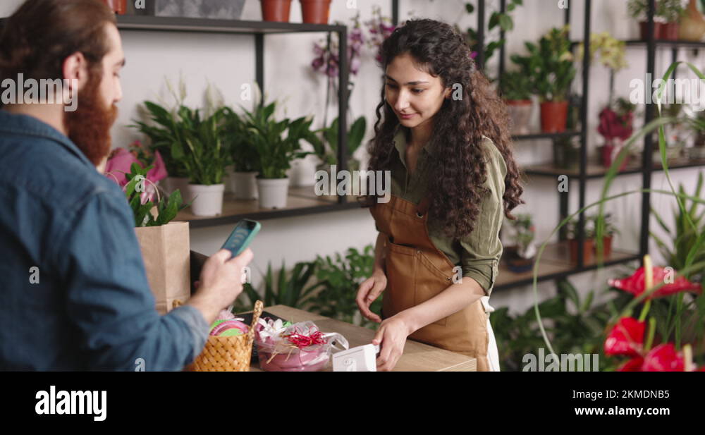 Customer paying for purchase in flower shop using nfc mobile technology