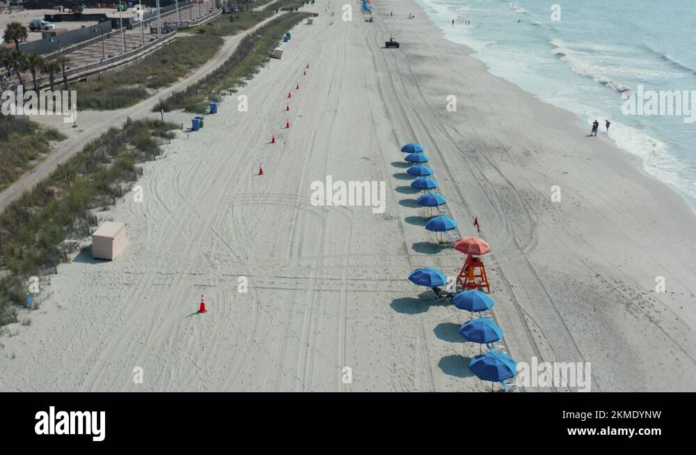 Myrtle Beach South Carolina beach. Umbrellas set up as people walk on