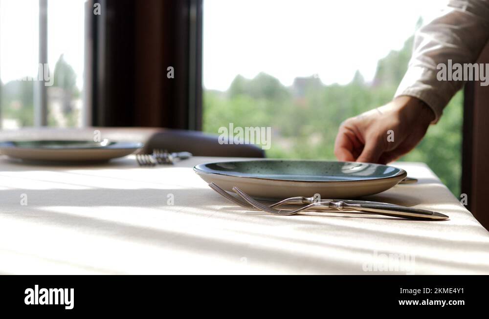 Waiter serves a table in an elite restaurant closeup. Men's hands