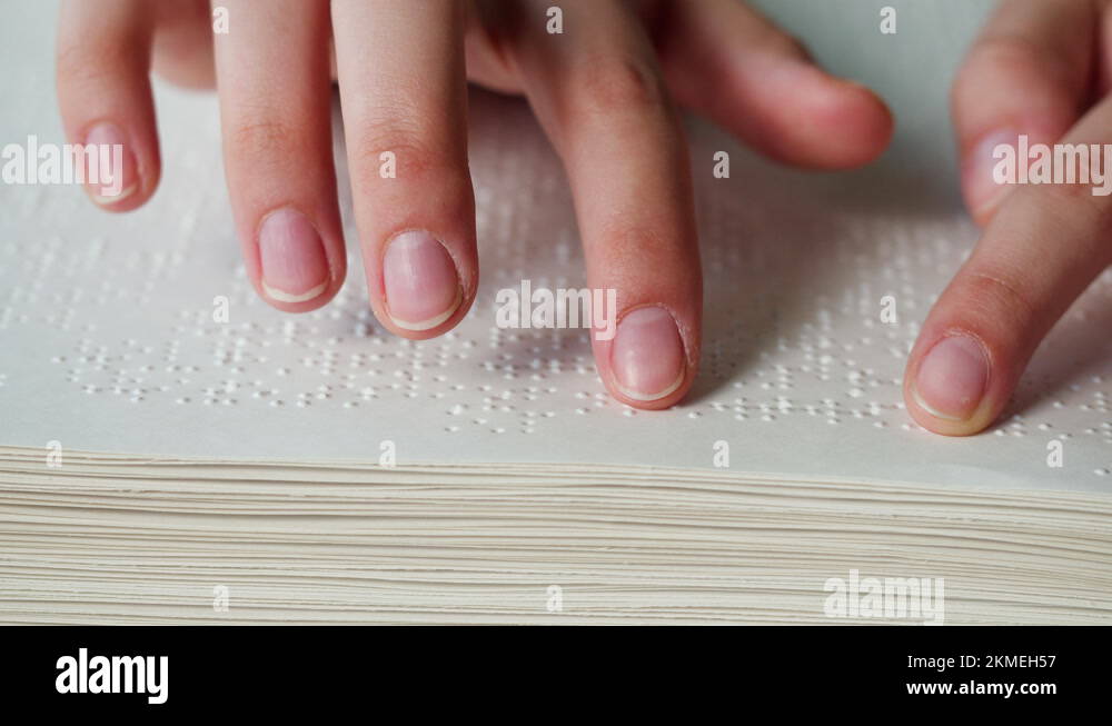Blind person reading with his hands using braille book, poorly seeing