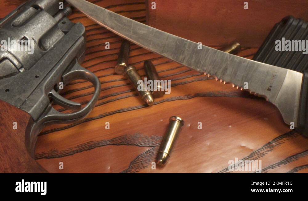 Gun bullets falling onto wood with gun and knife Stock Video Footage