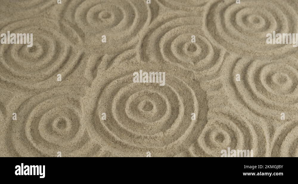 Spinning many circles in the sand. The circular texture of sand. Close