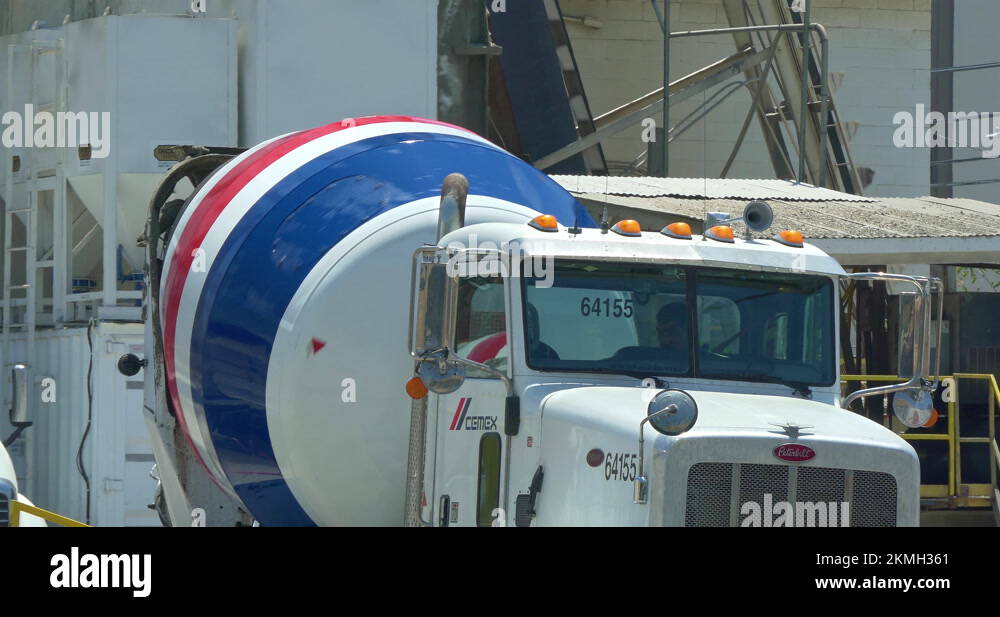 Conveyor belt pouring concrete into mixer truck at industrial cement