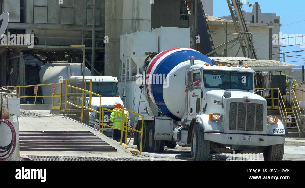 Conveyor belt pouring concrete into mixer truck at industrial cement