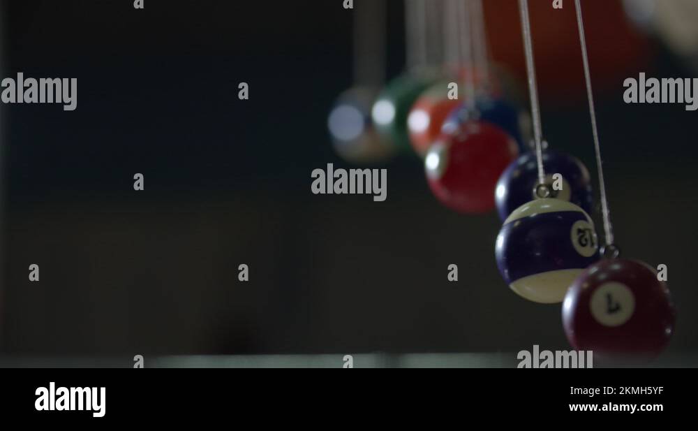 Balls on strings are swinging creating an interesting visual effect, 4k