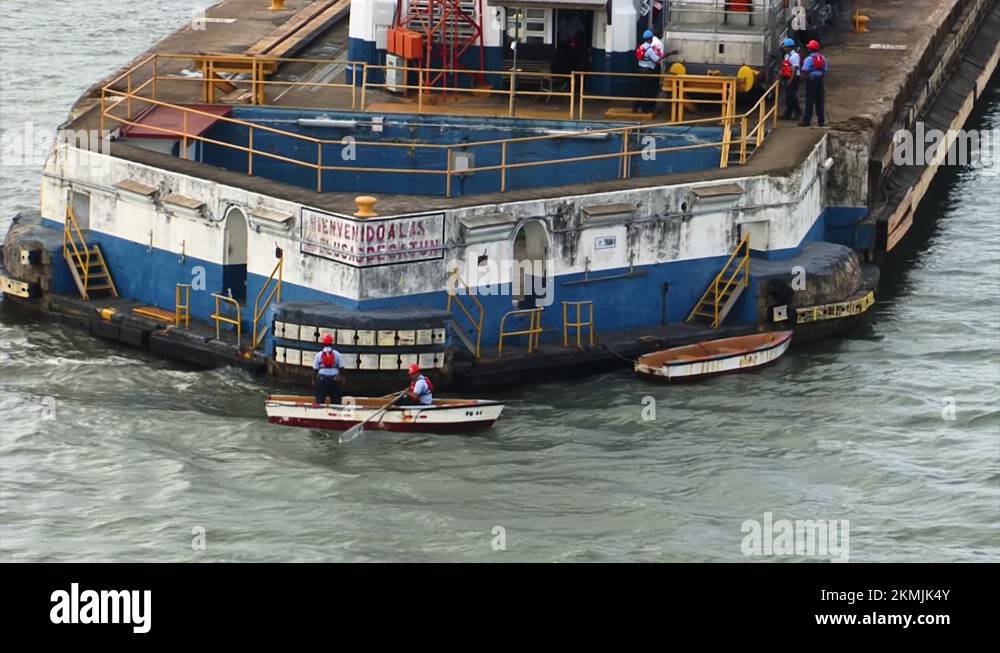 Workers of Panama Canal bringing the mooring lines to the ship in a