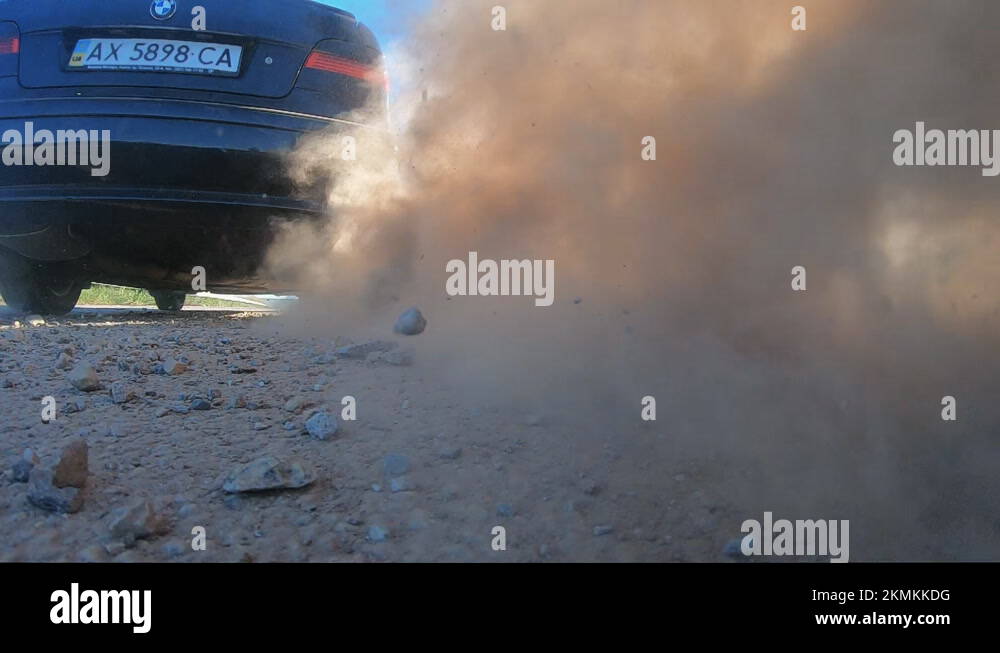 Wheel of a black car slipping on a asphalt road during start of