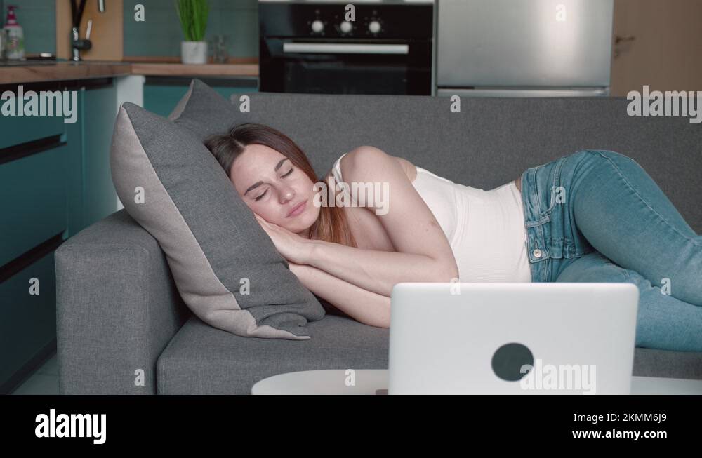 Apathetic young sleepy woman falls down on sofa. Exhausted tired lazy lady Stock Video Footage