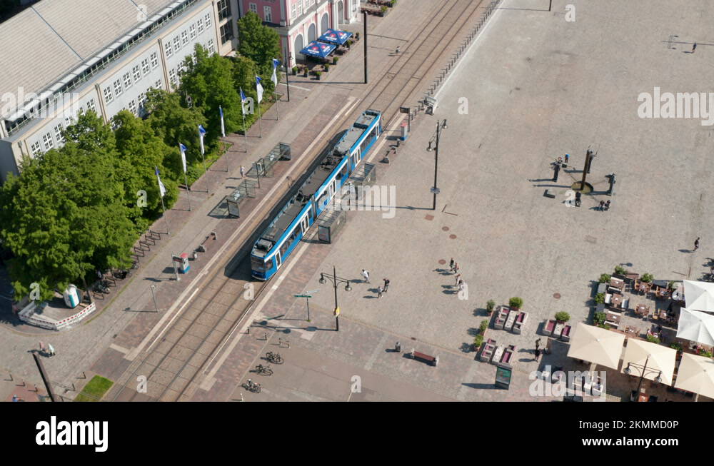 Descending and tilt up footage of tram leaving tram stop at Neue Markt