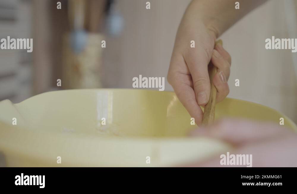 Woman finishes mixing batter for Bundt cake. She drips the batter in ...